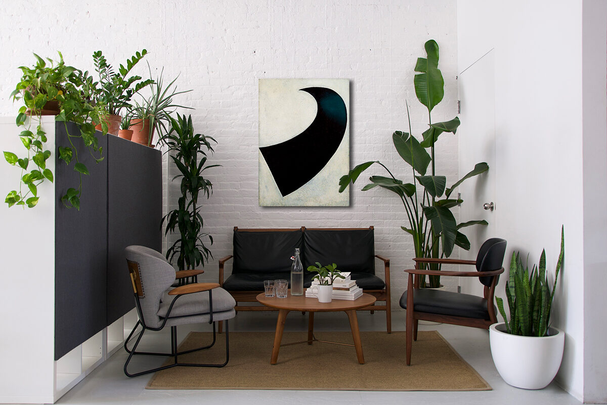 Lounge corner with black leather seating, a round table, and a black-and-white artwork